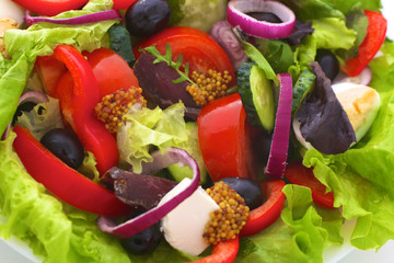 salad from fresh vegetables in a plate on a table, selective focus