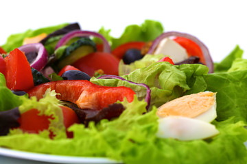 salad from fresh vegetables in a plate on a table, selective focus