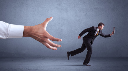 Fototapeta premium Businessman running from hand