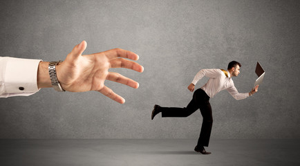 Businessman running from hand