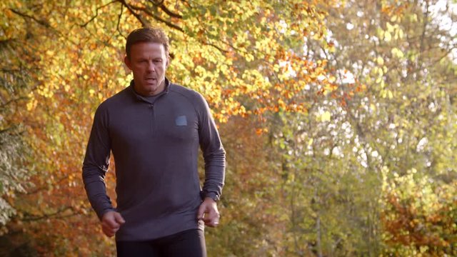 Mature Man Running Through Autumn Landscape In Slow Motion