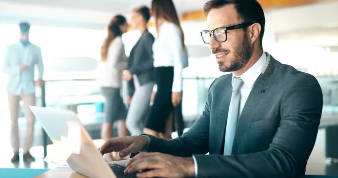Young handsome architect working on laptop in office