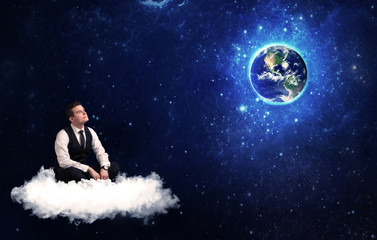 Fototapeta na wymiar Man sitting on cloud looking at planet earth