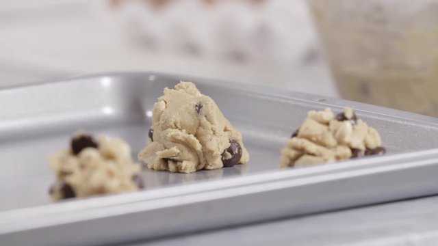Close up, baker places cookie dough on sheet