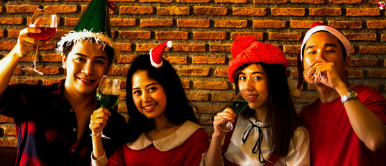 Fototapeta premium The acting setup of Christmas party concept. The two young couple enjoy together in the Xmas party and all the mambers has a drink to celebrate together.