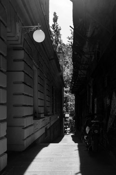 High contrast street photo European capital Ljubljana strong hard shadow passage alley 