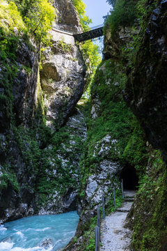 Blue mountain river floats through the tall canyon cave like tunnel in mountain Slovenia 