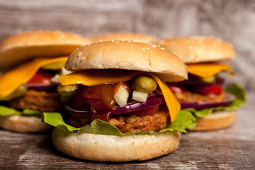 Gourmet tasty burgers on wooden background. Fast and tasty food