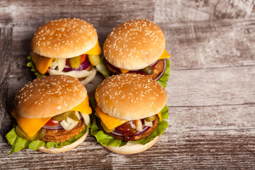 Delicious tasty hamburgers on wooden background. Fast and tasty food