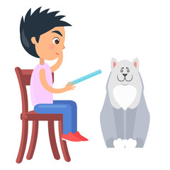 Boy on Chair Reads from Tablet Beside White Dog