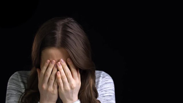Studio Shot Of Scared Young Woman Flinching From Abuse