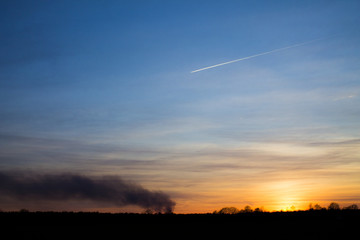 Fototapeta na wymiar Sunset, smoke and plane