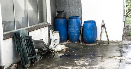 Barrels of toxic liquid waste behind a filling station building