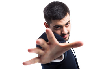 A man in a business suit, on a white background, a fixed look and an outstretched palm to the...