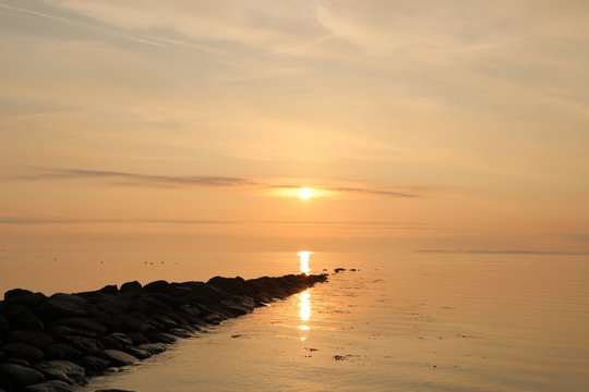 malerischer Sonnenaufgang an einer Buhne an der Ostsee