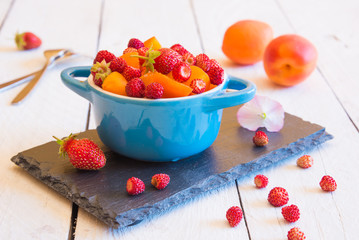 Fruit salad with wild strawberries in a bowl