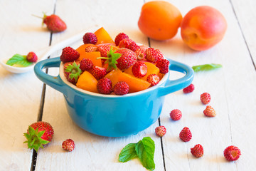 Fruit salad with wild strawberries in a bowl