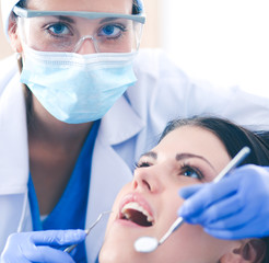 Woman dentist working at her patients teeth