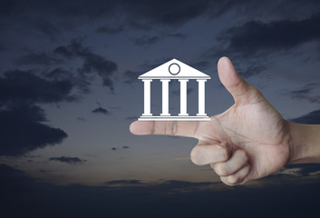 Fototapeta na wymiar Bank icon on finger over sunset sky, Business banking online concept