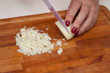 Cook chopped onion on the board with knife