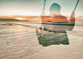 Double exposure of kid on swing and beautiful seascape sunset