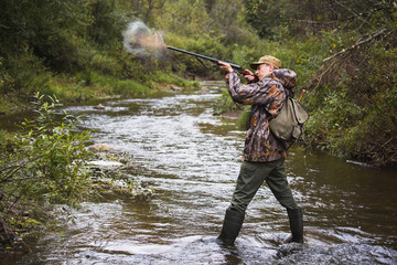 Naklejka premium The hunter shoots from the hunting rifle. 
