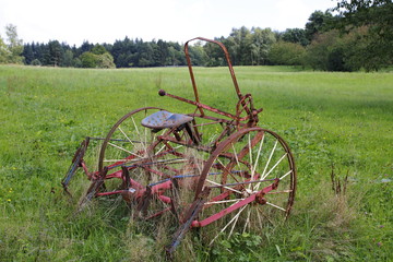 Alter, rostiger Traktor, Mähdrescher auf einer Wiese, einem Feld © HeiSpa