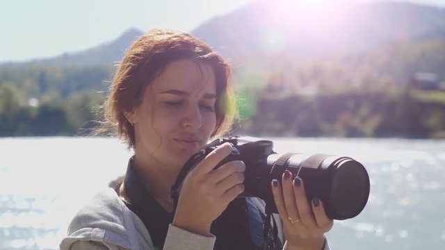 Beautiful woman with red hair photographer taking photo using professional camera outdoors on hike. Female hiker taking pictures outside living outdoor lifestyle in nature landscape. 3840x2160