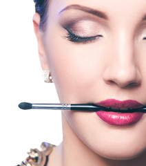 Woman's lips holding make up brush