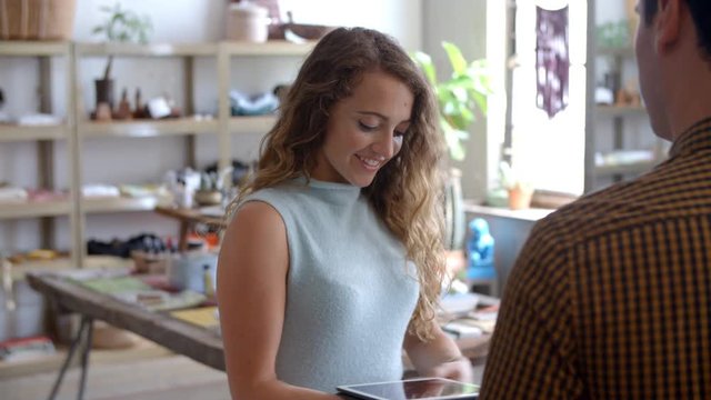 Shop assistant takes customer card payment with tablet