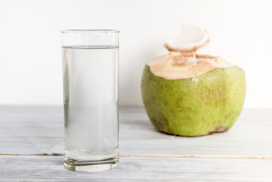 a glass of coconut water on wooden table