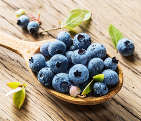 Blueberries in the wooden spoon on the table.