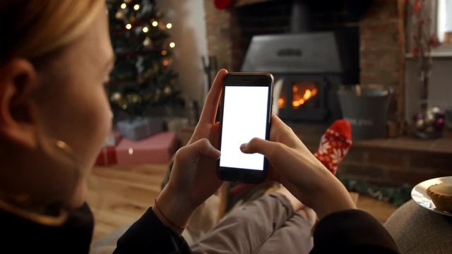 Woman On Line With Mobile Phone In Room Ready For Christmas