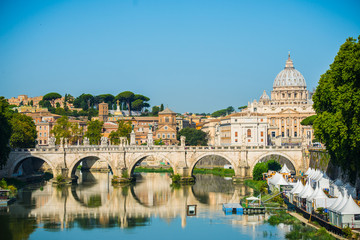 Fototapeta na wymiar St. Peter's cathedral over bridge and river in Rome, Italy