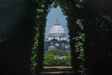 Obraz premium The dome of Saint Peters Basilica seen through the famous keyhole at the the gate of the Priory of the Knights of Malta on Aventino Hill. Rome, Italy, Southern Europe