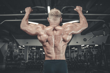 Fototapeta na wymiar Handsome model young man training back in gym