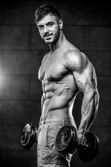 Obraz na płótnie Canvas Handsome model young man training abs in gym