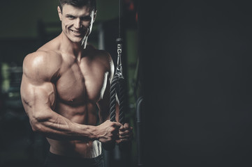 Obraz premium Handsome model young man training arms in gym