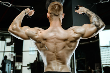 Handsome model young man training back in gym
