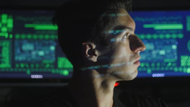 portrait of a young programmer with a binary code on his face in a cyber office