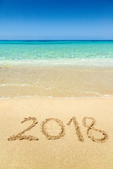 2018 written on sandy beach