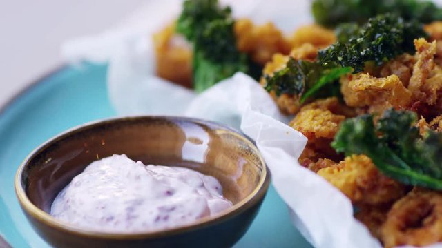 Fried squid with kale and sumac mayo, extreme close up, pan