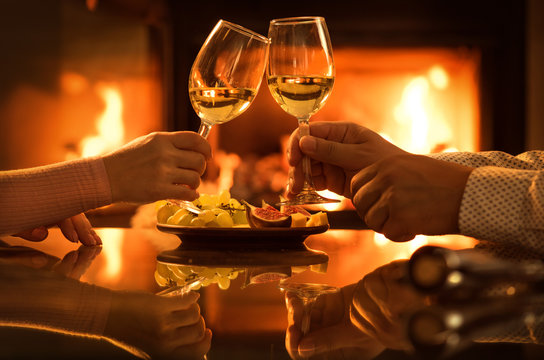Young couple have romantic dinner with wine over fireplace background. Romantic concept .