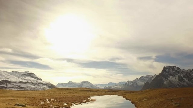 backward POV walking on fall valley lake and snowy mounts to sunset.Sunny autumn day Hiking in colorful red forest wild nature mountain outdoors.Alps Devero.4k point of view establishing video