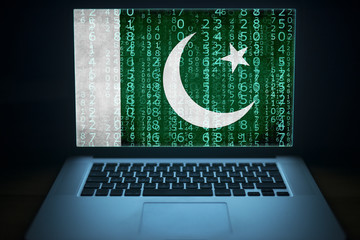 Pakistan internet security.  Laptop with binary computer code and Pakistani flag on the screen....