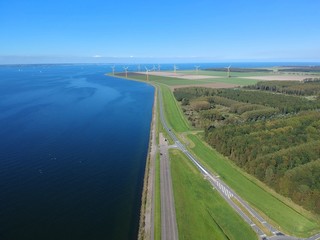 Aerial (drone) view of a Dutch dike and in the polder of Flevoland (Almere Poort), The Netherlands.