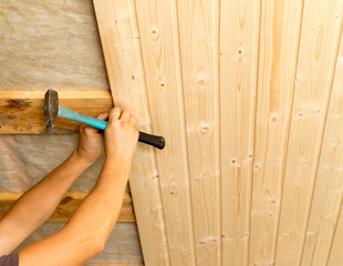 worker working on a wooden ceiling in the house