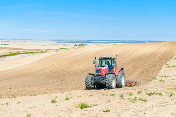 Obraz premium agricultural tractor in the foreground with blue sky background.