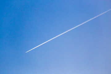 trail from the plane in the sky at sunset