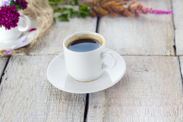 Composition with flowers and a coffee cup on white background.